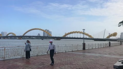 People walking by the Han river of Da Nang, viewing Dragon Bridge Stock Footage 146251100