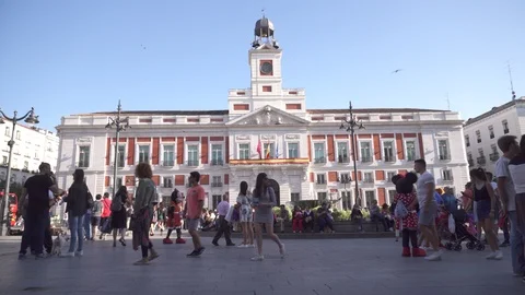 People walking near to clock tower on a plaza Puerta del Sol in Madrid Stock Footage 89539367