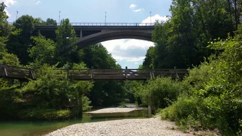 People walking over double bridge above green river. Stock Footage 133613353