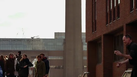 People walking over Millennium bridge with Tate Modern in  background Stock Footage 71912441