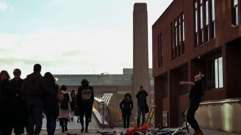 People walking over Millennium bridge with Tate Modern in  background Stock Footage 71912899