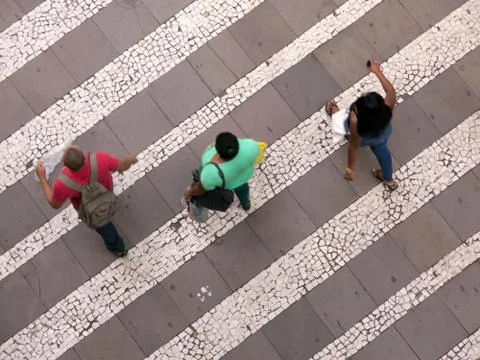 People walking over pattern sidewalk - birds eye Stock Photos