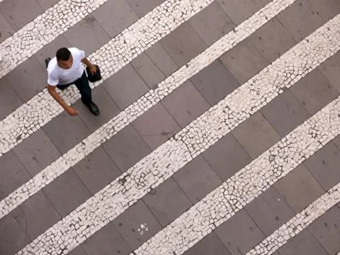 People walking over pattern sidewalk - birds eye Stock Photos
