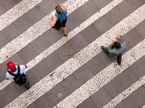 People walking over pattern sidewalk - birds eye Stock Photos
