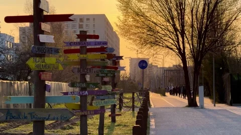 People Walking in Park at Sunset with Direction Signs in Bucharest Stock Footage 331935483