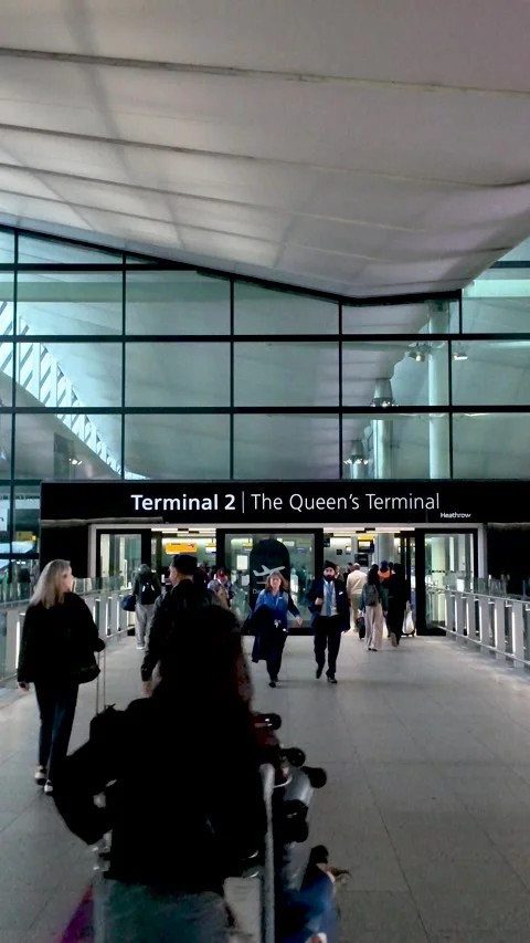 People walking past automatic doors at a modern airport terminal. Vertical video Stock Footage 320225867