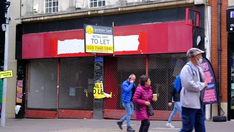 People Walking Past An Empty Closed Shop  On A London High Street Stock Footage 163235844