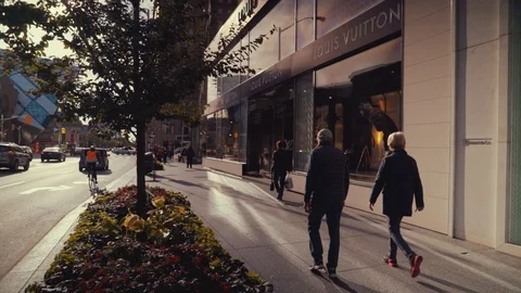 Pedestrians walking past the Louis Vuitton store on 5th avenue