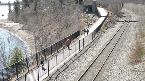 People Walking on Path Next to Water and Train Tracks 스톡 동영상 66365811