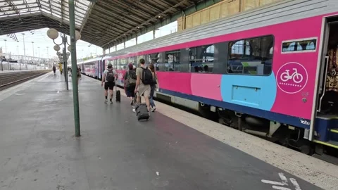 People Walking On The Platform Next To A Pink And Blue OUIGO Train At The Stock Footage 342320254