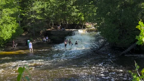 People Walking, Playing in a Waterfall Stock Footage 166184149