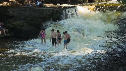People Walking, Playing in a Waterfall Stock Footage 166184156