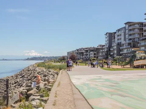 People walking on Point Ruston waterfront promenade with modern apartments .. Foto stock