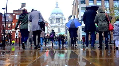 People walking in the rain with umbrellas Stock Footage