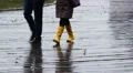 People walking in the rain on a wooden embankment, gloomy and dark autumn day HD Footage