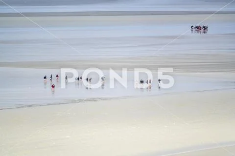 People walking on the sand during low tide, Mont-Saint-Michel, Normandy, France, Stock Photos