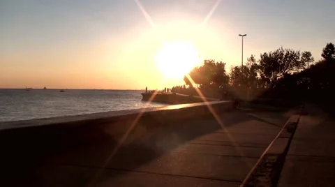 People walking at the seaside in sunset Stock Footage 68710593