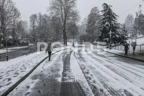 People Walking On Snow Covered Road