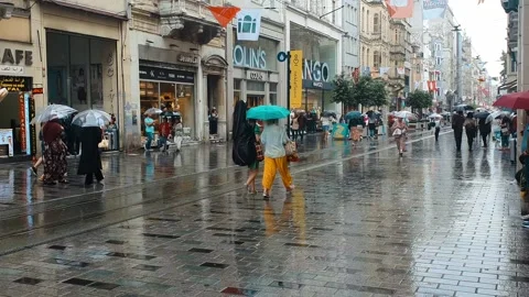 People walking  at Taksim square in Beyoglu area of Istanbul in a rainy day. Stock Footage 245178331