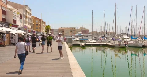 People walking through Cap D'Agde Marina promenade, France Video stock 314375756