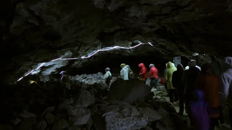 People walking through the cave Stockbeeldmateriaal 76689023