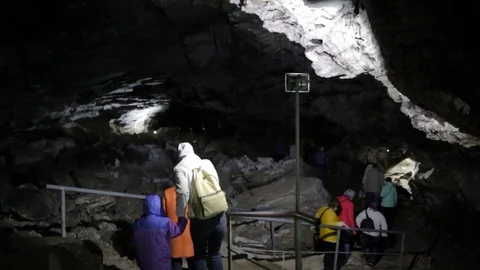 People walking through the cave Stock Footage 76689118