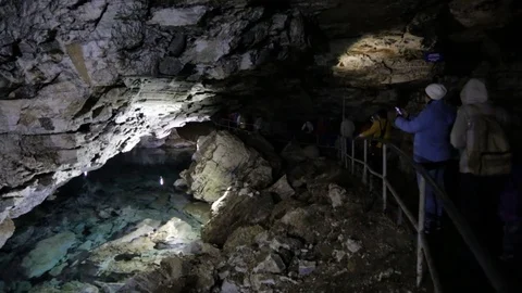 People walking through the cave Stock Footage 76689185