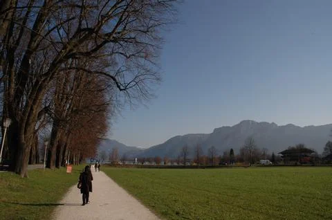 People Walking Through Green Fields Toward the Austrian Alps Foto stock