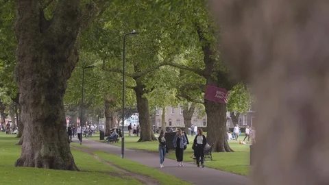 PEOPLE WALKING THROUGH LONDON FIELDS PARK Stock Footage 126708160