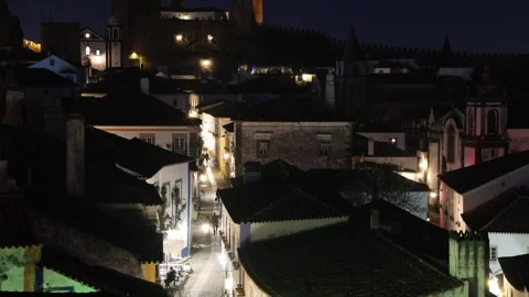 People walking through the medieval town of Óbidos at night Stockbeeldmateriaal 334008236
