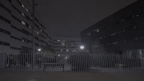 People walking through a modern building complex at night 스톡 동영상 320539335