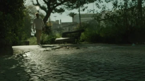 People walking through a park with paving stones in summer Stock Footage 273696627