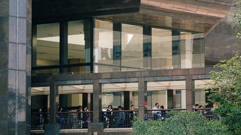 People walking through passage of modern office building Hong Kong slow motion 動画素材 110524444