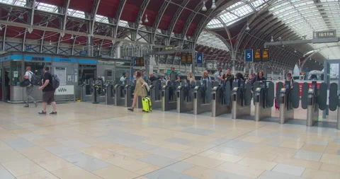 People Walking through Train Station Arrivals Barrier Gate at London Paddington Stock Footage