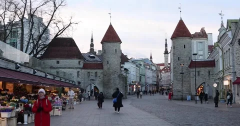 People walking through Viru Gate towards Tallinn Old Town at dusk Stock Footage 321049105