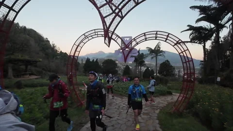 People walking under heart shaped structures on a mountain Stock Footage 295574792