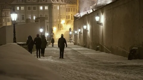 People Walking Under a Heavy Snowfall in a Street of Prague near the Castle Stock Footage 72145429