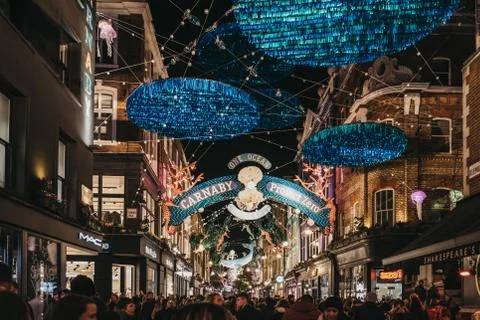 People walking under Project Zero sustainability themed Christmas lights in C Foto stock