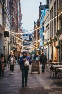 People walking under the strings of lights in Kingly Street, London, UK. Stock Photos