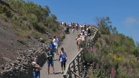 People walking uphill on footpaths of Mount Vesuvius to get to the top, blue sky Video stock 113260441
