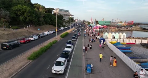 People Walking on wide pavement parallel with coastal road Video stock 202173830