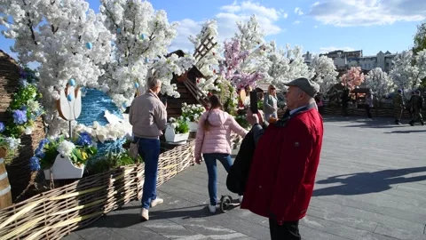 People walks next to Easter holiday decorations Stock Footage 239934384