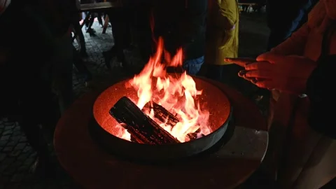 People warm themselves around the fire during cold night. Stock Footage 226579219