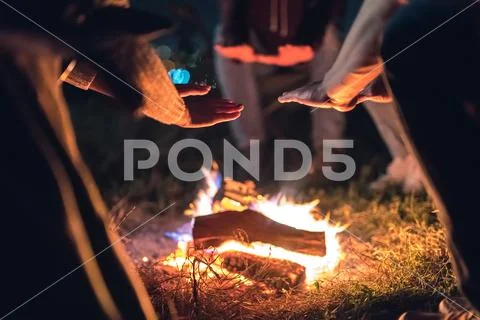 The people warming hands near the bonfire. night time Stock Photos