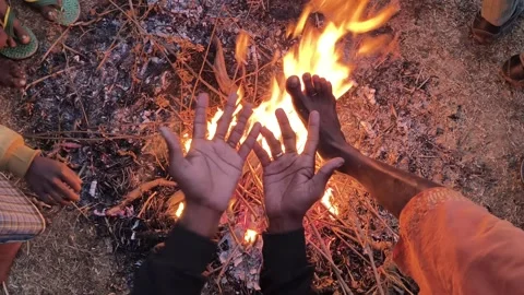 People warming their hands and feet over a glowing campfire. 库存影片 326651306