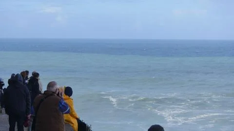People watch the big waves in Nazare, Portugal Stock Photos