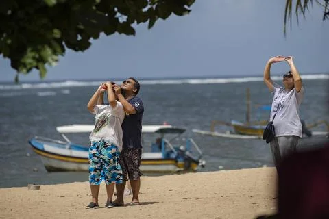 People watch partial solar eclipse in Bali, Denpasar, Indonesia - 20 Apr 2023 Fotos Stock
