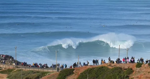 People watching the big giant waves crashing in Nazare Stock Footage 221656972