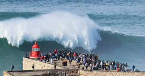 People watching big waves crashing in Nazare. Biggest waves in the world Stock Footage