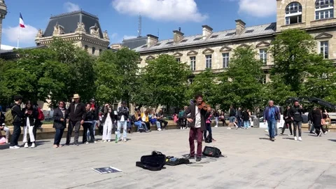 People Watching Busker Playing Violin Outside The Notre Dame Cathedral In Stock Footage 217896122
